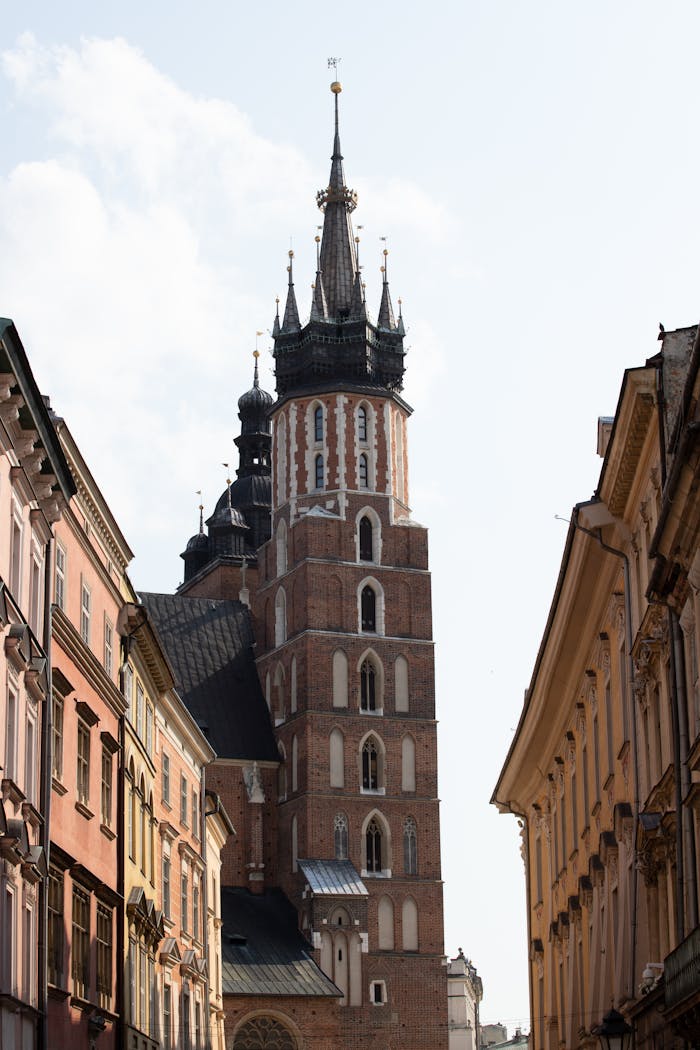 our-experience A view of St. Mary's Basilica tower between historic buildings in Krakow, Poland.