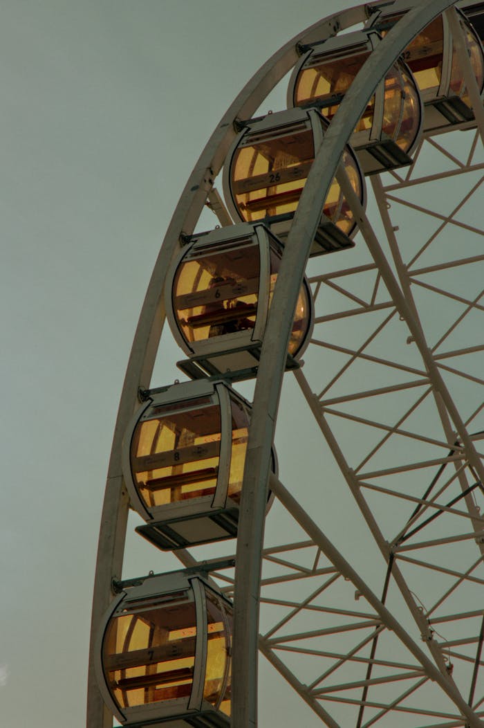 services-01 Close-up view of a Ferris wheel in Kraków, Poland against a dusky sky, capturing a moment of calm.