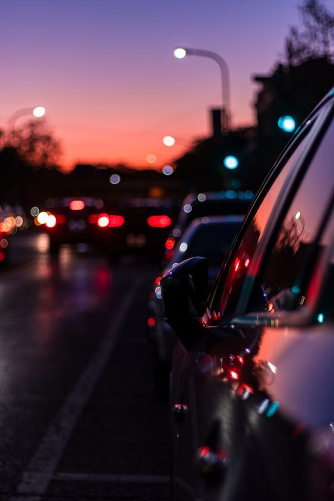 pexels photo 3066867 Blurred city street scene at dusk with vibrant lights reflecting on car surface, capturing nightlife essence.